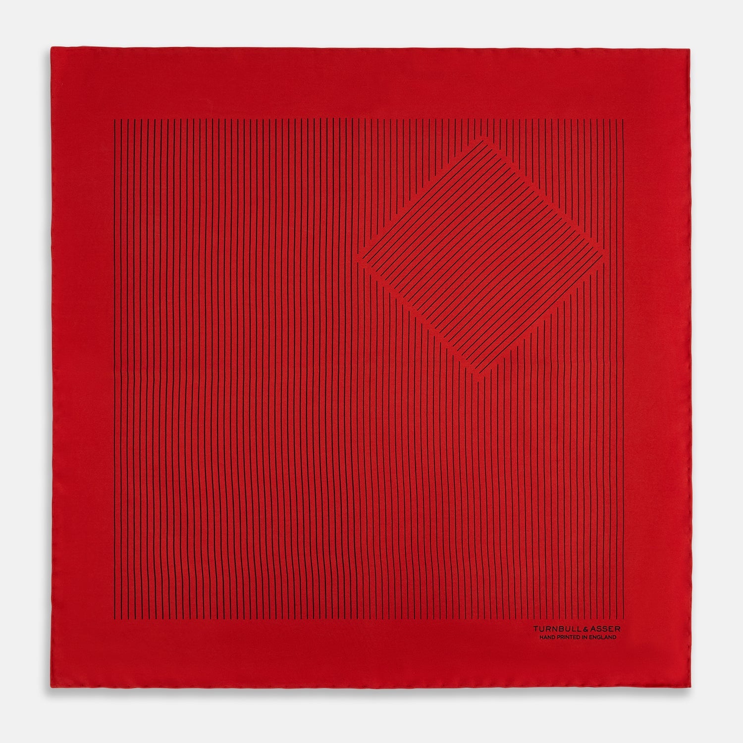 View 3 of product The Red Stripe Silk Pocket Square by Turnbull & Asser features thin black vertical lines and the brand signature in black on one corner, with a neatly folded edge for a touch of classic British style.