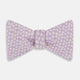 The Turnbull & Asser Lilac Flower Patterned Silk Bow Tie showcases small white flowers on lilac silk, making it a refined accessory for smart outfits. Shown against a white background.