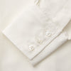 View 4 of product The Cream Silk Tailored Bianca Shirt by Turnbull & Asser features long sleeves, a pointed collar, and curved hem in soft-touch peace silk with a tailored fit. Shown laid flat on a white background.