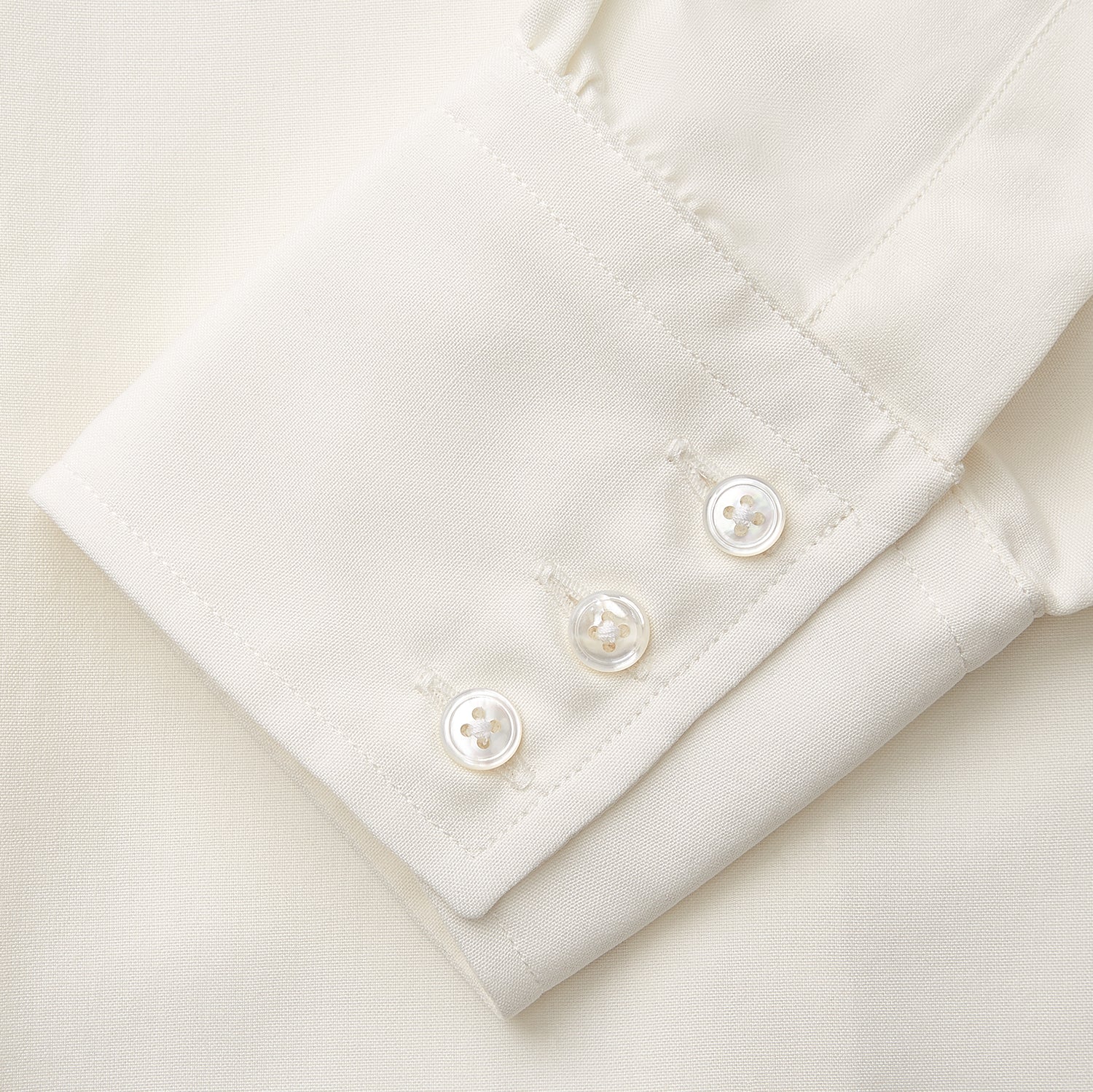 View 4 of product The Cream Silk Tailored Bianca Shirt by Turnbull & Asser features long sleeves, a pointed collar, and curved hem in soft-touch peace silk with a tailored fit. Shown laid flat on a white background.