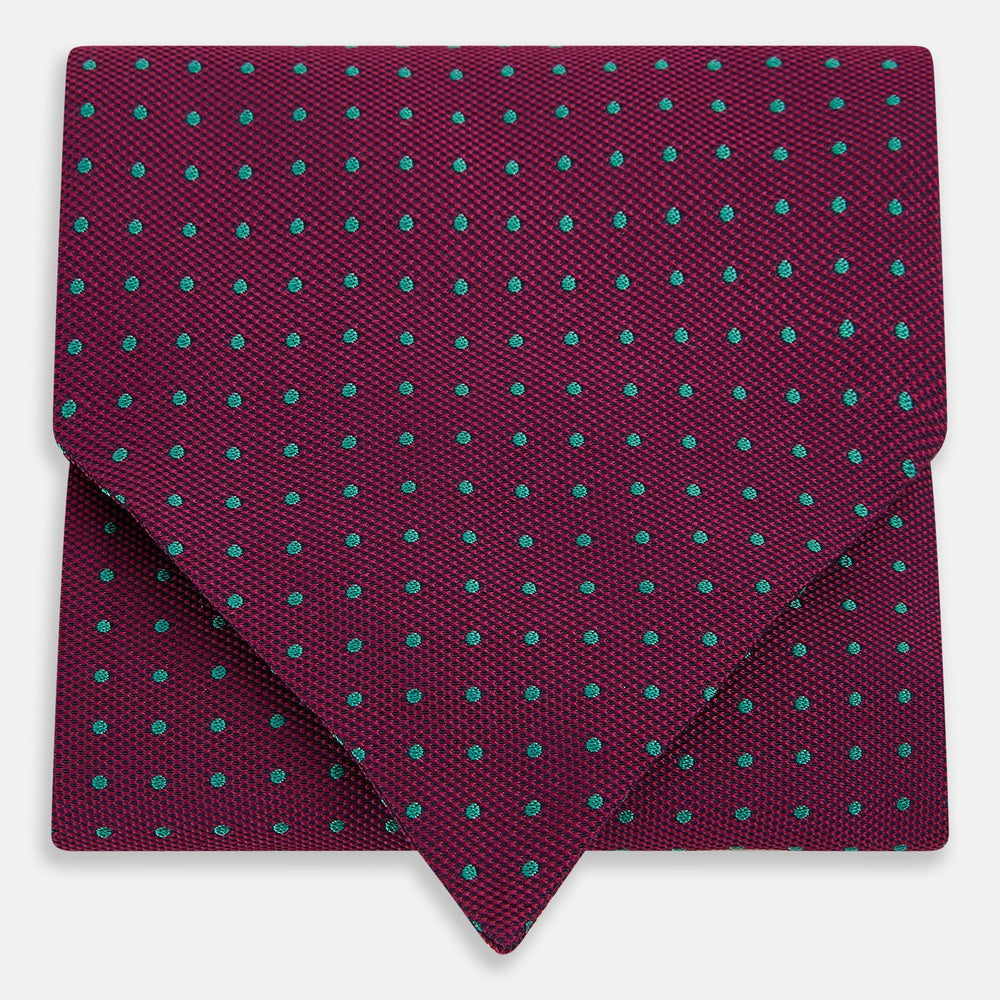 A burgundy pocket square with turquoise polka dots, folded to a point—an ideal men's formal accessory to complement the Green Micro Dot and Magenta Silk Cravat by Turnbull & Asser.