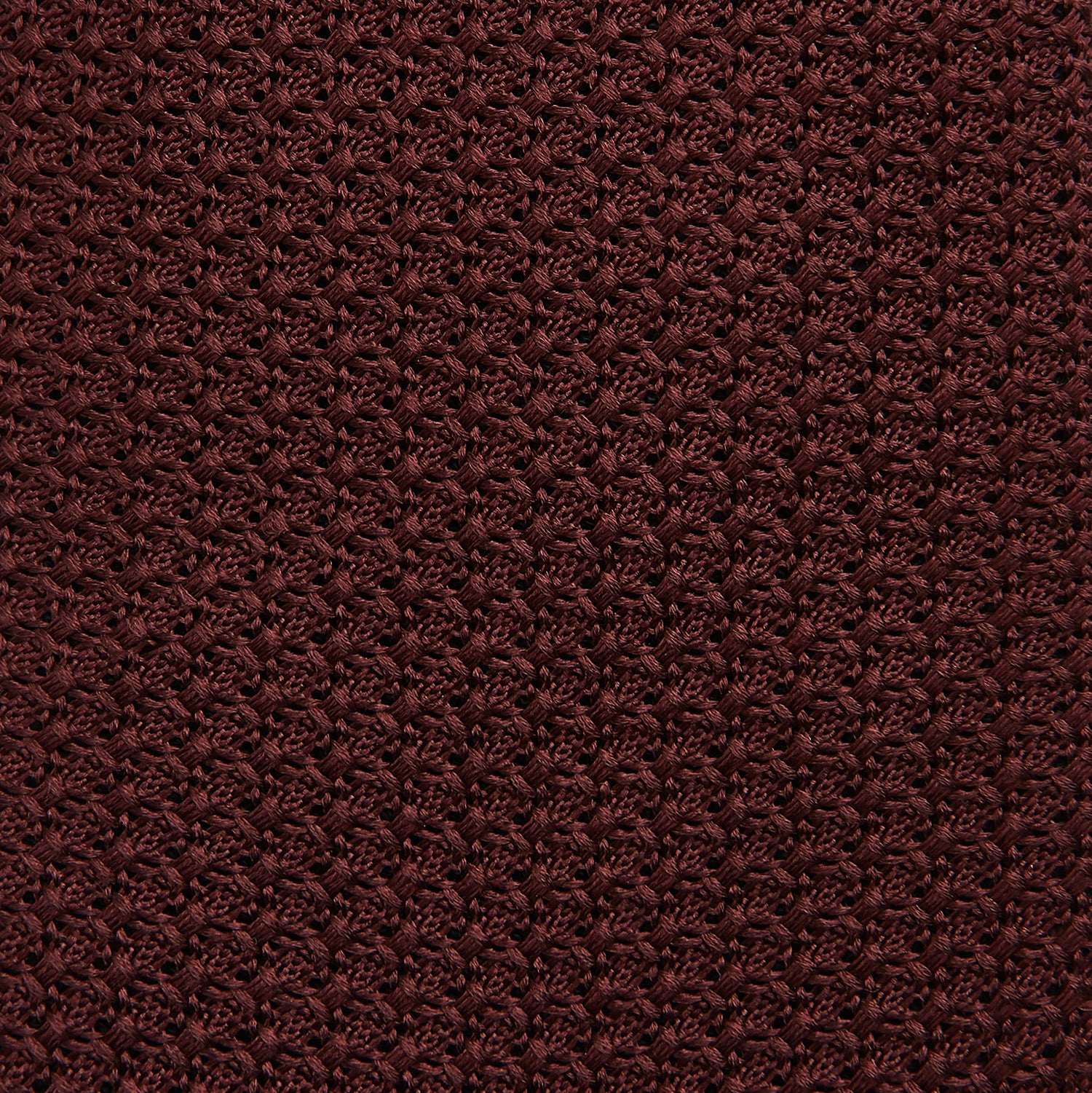 View 3 of product The Turnbull & Asser Burgundy Knitted Tie, rolled and featuring a textured pattern, is displayed on a plain white background—a refined accessory ideal for the modern gentleman’s wardrobe.