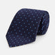 The LACE ON TONE SPOT NAVY FORD TIE by Turnbull & Asser is a rolled-up navy tie with textured fabric and an evenly spaced pattern of small light blue polka dots.