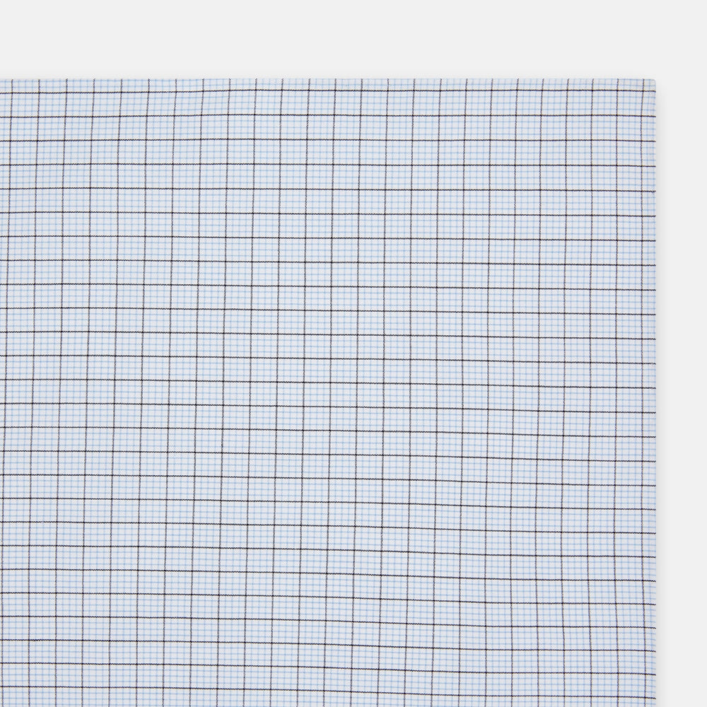 The Hand Rolled Blue Multi Graph Check Handkerchief by Turnbull & Asser features a white base with a blue grid and bold lines, resembling elegant graph paper, set against a clean white background.