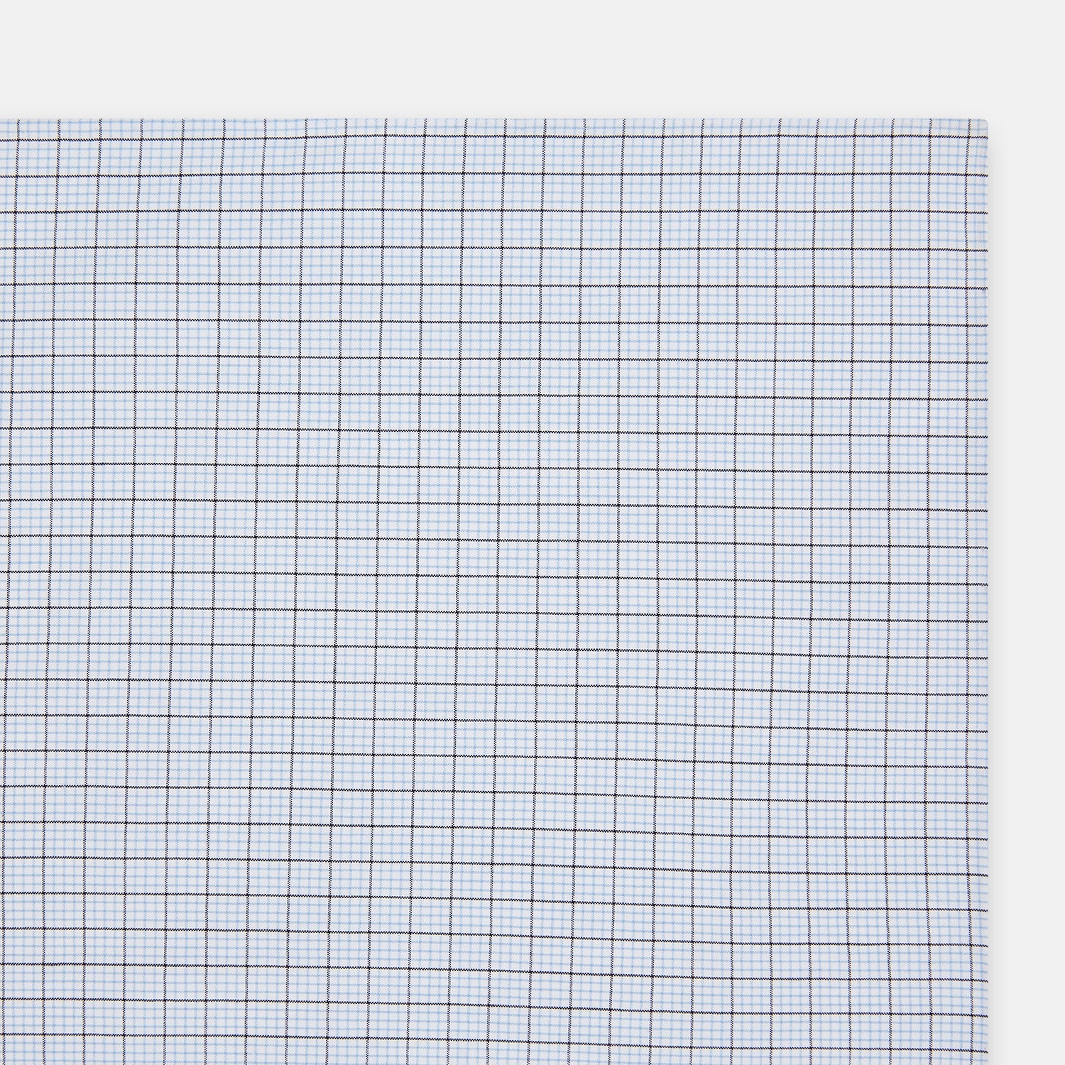 View 2 of product The Hand Rolled Blue Multi Graph Check Handkerchief by Turnbull & Asser features a white base with a blue grid and bold lines, resembling elegant graph paper, set against a clean white background.