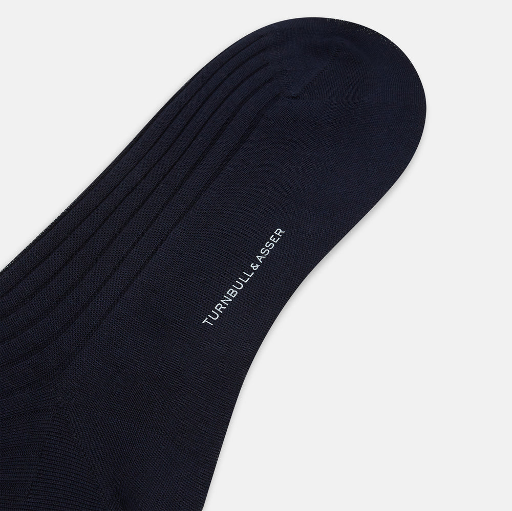 A single navy long sock by Turnbull & Asser, featuring a subtle ribbed texture and crafted from soft Egyptian cotton, displayed on a plain white background.