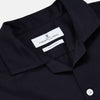View 2 of product A Navy Cotton Holiday Fit Winnington Shirt by Turnbull & Asser, featuring long sleeves, a chest pocket, white buttons, and a revere collar, is laid flat on a white background.