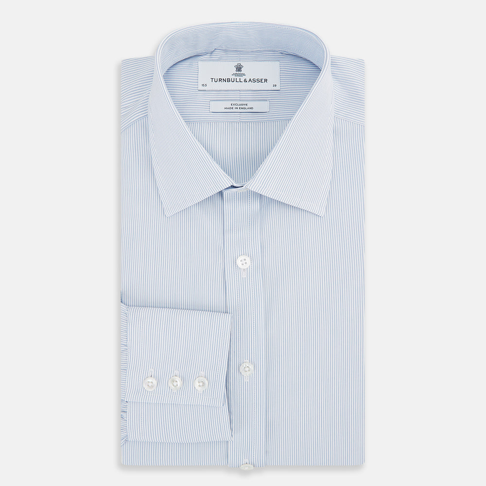 The Turnbull & Asser Sky Blue Hairline Multi Stripe Mayfair Shirt features Italian cotton, long sleeves, a classic collar, white buttons, and a subtle stripe pattern, shown on a plain white background.