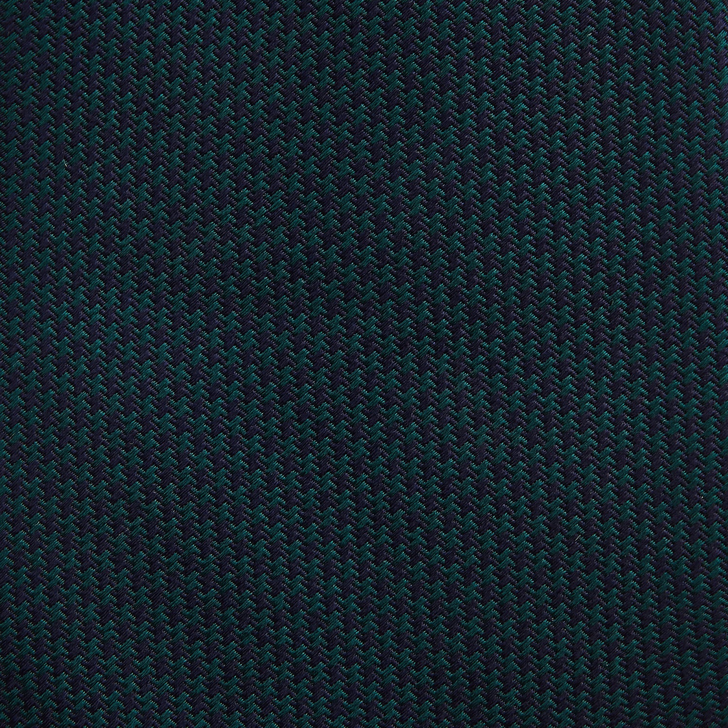 View 3 of product The Turnbull & Asser Navy Houndstooth Forest Green Tie is shown rolled up, featuring a subtle houndstooth pattern against a plain white background.