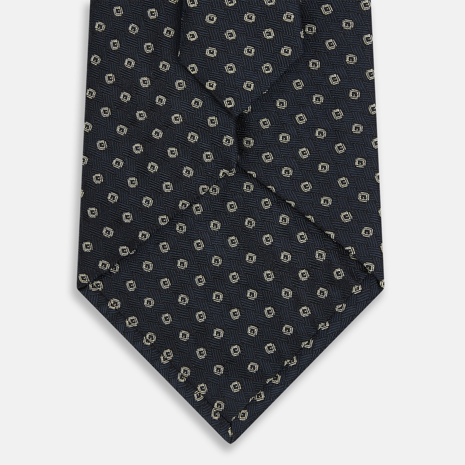 View 3 of product The Turnbull & Asser Navy and White Circle Silk Tie features a repeating circle pattern and is shown rolled on a white background—a timeless men's accessory for any occasion.