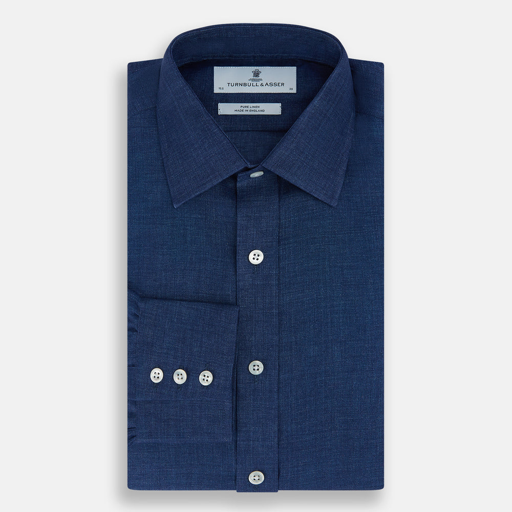The Turnbull & Asser Navy Linen Mayfair Shirt features long sleeves, a button-up front with white buttons, pointed collar, buttoned cuffs, and a classic fit in solid dark blue linen, shown on a white background.
