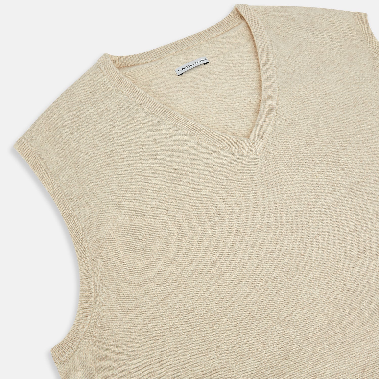 View 2 of product The Turnbull & Asser Cream Cashmere V-neck Vest features a sleeveless design and ribbed hem, presented on a plain white background—a refined update to the classic men’s sweater.