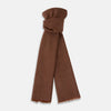 View 1 of product The Turnbull & Asser Brown Cashmere Scarf is ultra-soft with a smooth texture, short frayed edges, and is tied in a simple knot. Displayed against a plain white background.