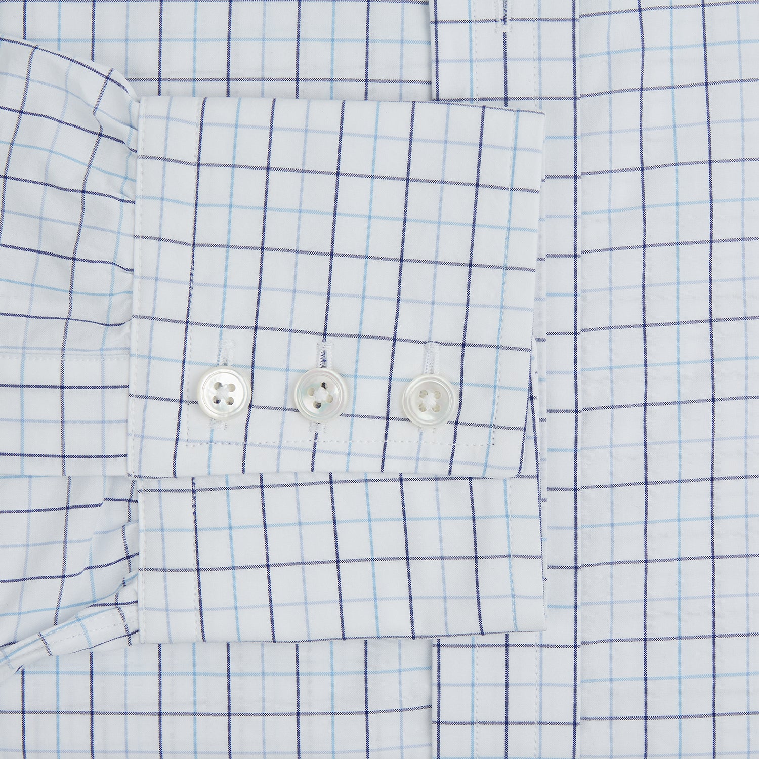 View 4 of product The Blue Overlay Grid Check Mayfair Shirt by Turnbull & Asser features a light blue and white grid check pattern with long sleeves and button-up design, making it a versatile wardrobe staple. Displayed on a plain white background.