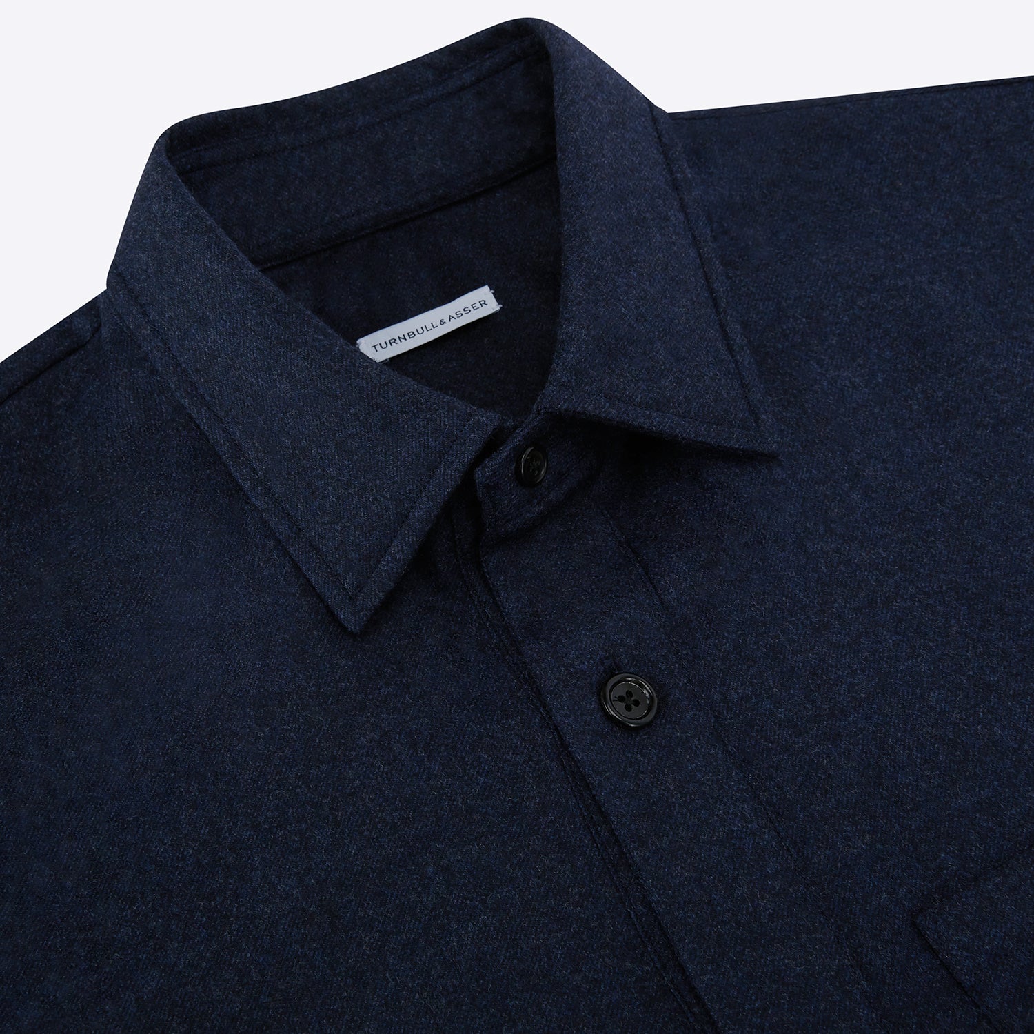 View 2 of product The Turnbull & Asser Mid Blue Highbury Overshirt features long sleeves, a button-up front, collar, and single chest pocket, shown laid flat on a white background.