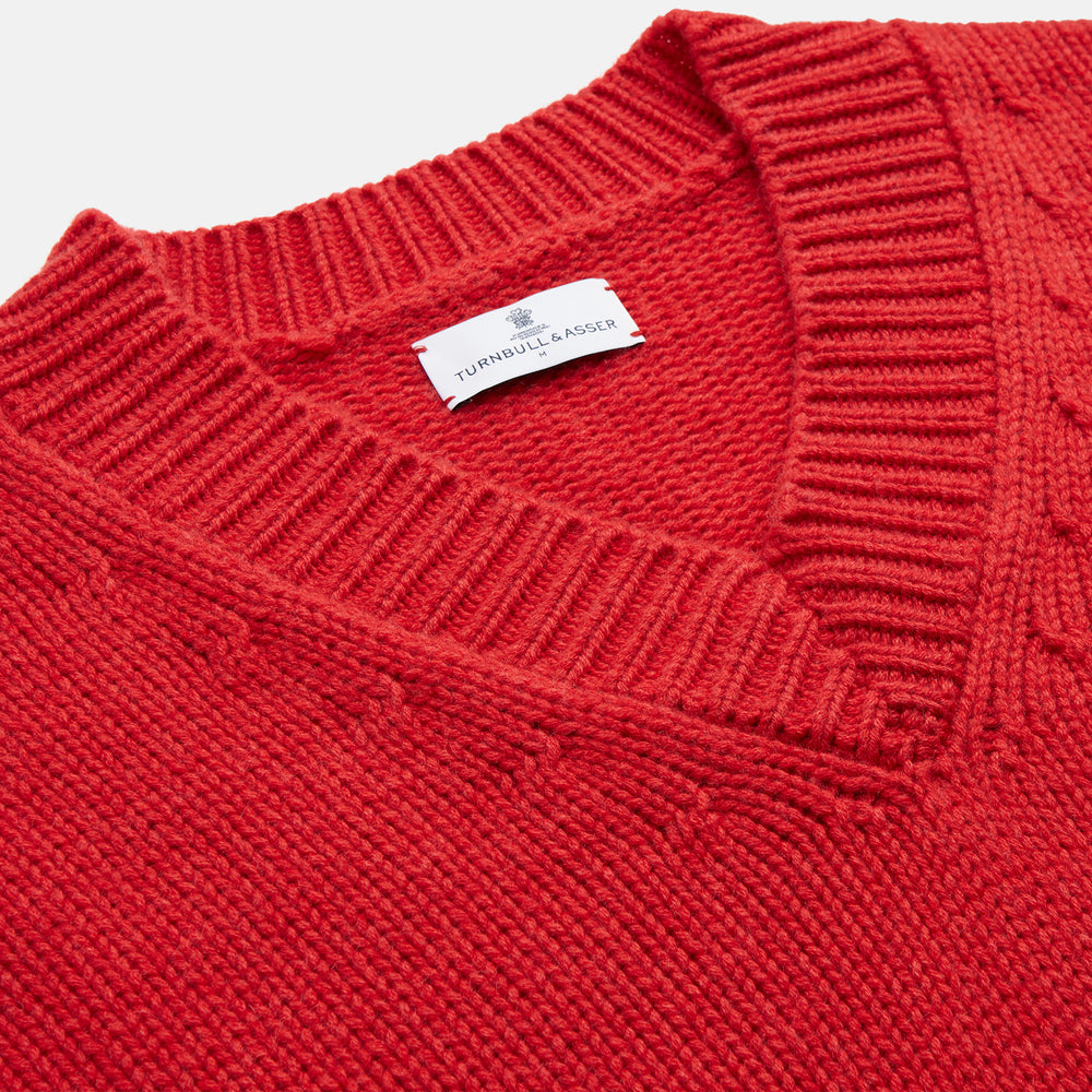 The Turnbull & Asser Raspberry Red Cashmere Edwards V-Neck Sweater features long sleeves, ribbed cuffs and hem, and is shown laid flat on a white background.