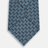 View 3 of product A close-up of the Turnbull & Asser Pale Blue and Navy Weave Patterned Silk Tie, featuring a textured geometric design. The silk tie is rolled at one end and displayed on a white background.