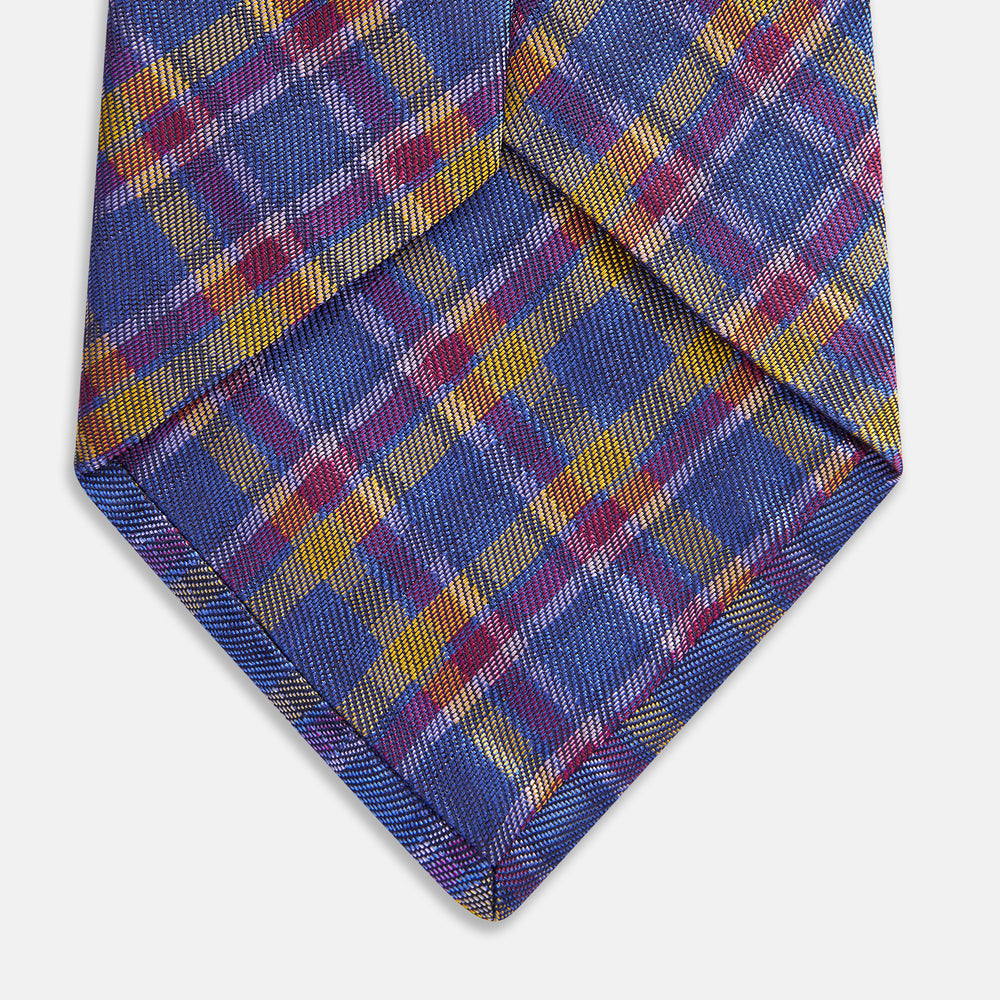 The Turnbull & Asser Blue Multi Tartan Silk Tie features a vibrant blue, yellow, and pink plaid pattern and is shown rolled up on a white background.