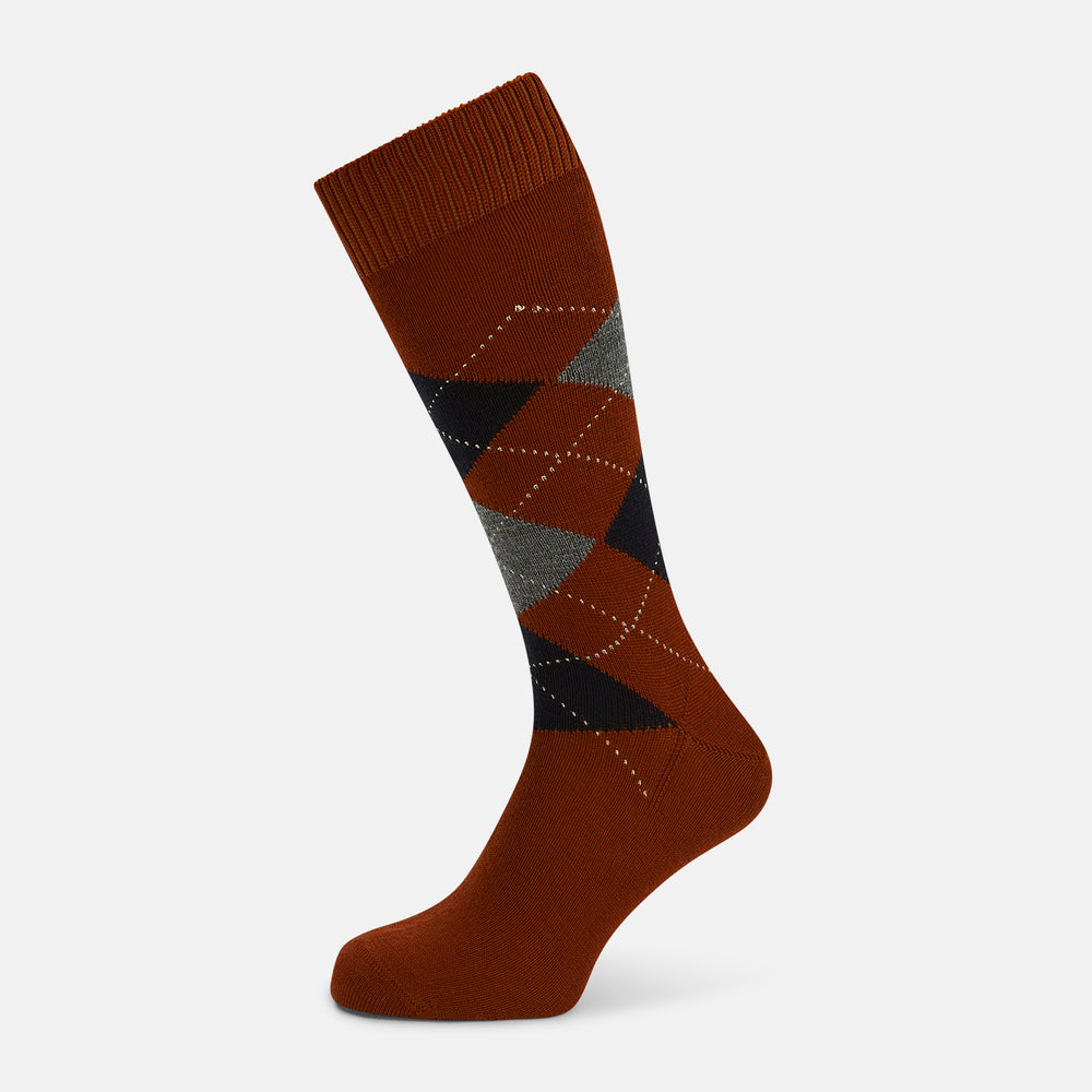 The Turnbull & Asser Rust Wool Check Mid-Length Sock features a brown wool design with black, gray, and orange checks, shown on a white background.