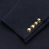 View 4 of product The Turnbull & Asser Short Navy Double Breasted Classic Blazer, featuring gold buttons, peaked lapels, and two front flap pockets, is displayed on a plain white background.