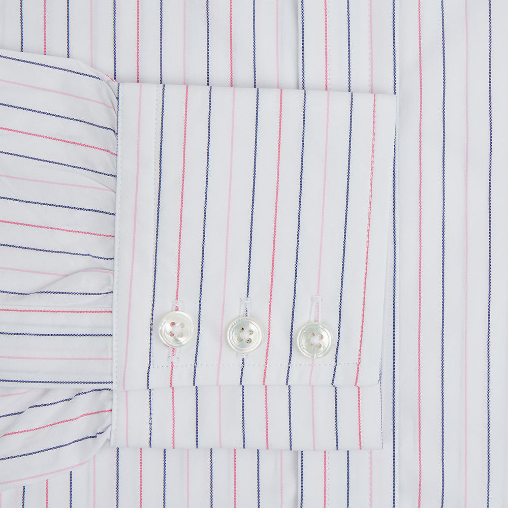 The Turnbull & Asser Pink and Blue Wide Pinstripe Mayfair Shirt features long sleeves, T&A collar, button-down front, and buttoned cuffs. It has bold pink and blue pinstripes on white and is laid flat on a white surface.