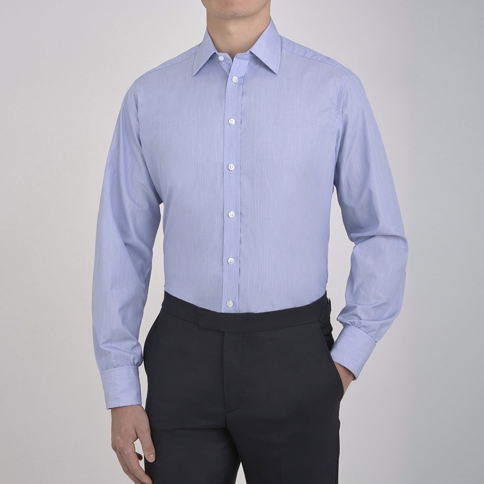View 2 of product The Turnbull & Asser Blue Hairline Stripe Shirt features a T&A collar, 3-button cuffs, and white buttons. Made from light blue cotton with subtle stripes, it’s neatly folded with the label visible inside the collar on a plain white background.