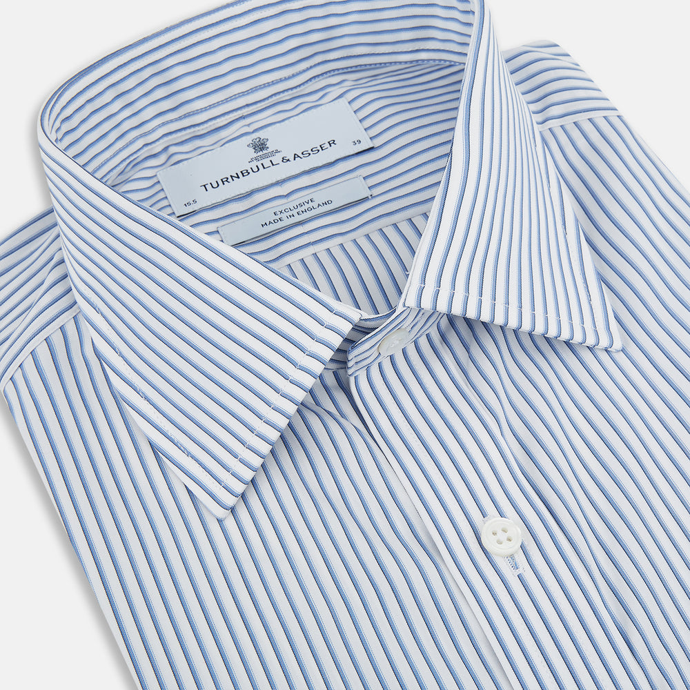 The Turnbull & Asser Blue Shadow Stripe Mayfair Shirt is a long-sleeve button-up with a T&A collar and thin blue vertical stripes on white, shown on a plain white background.