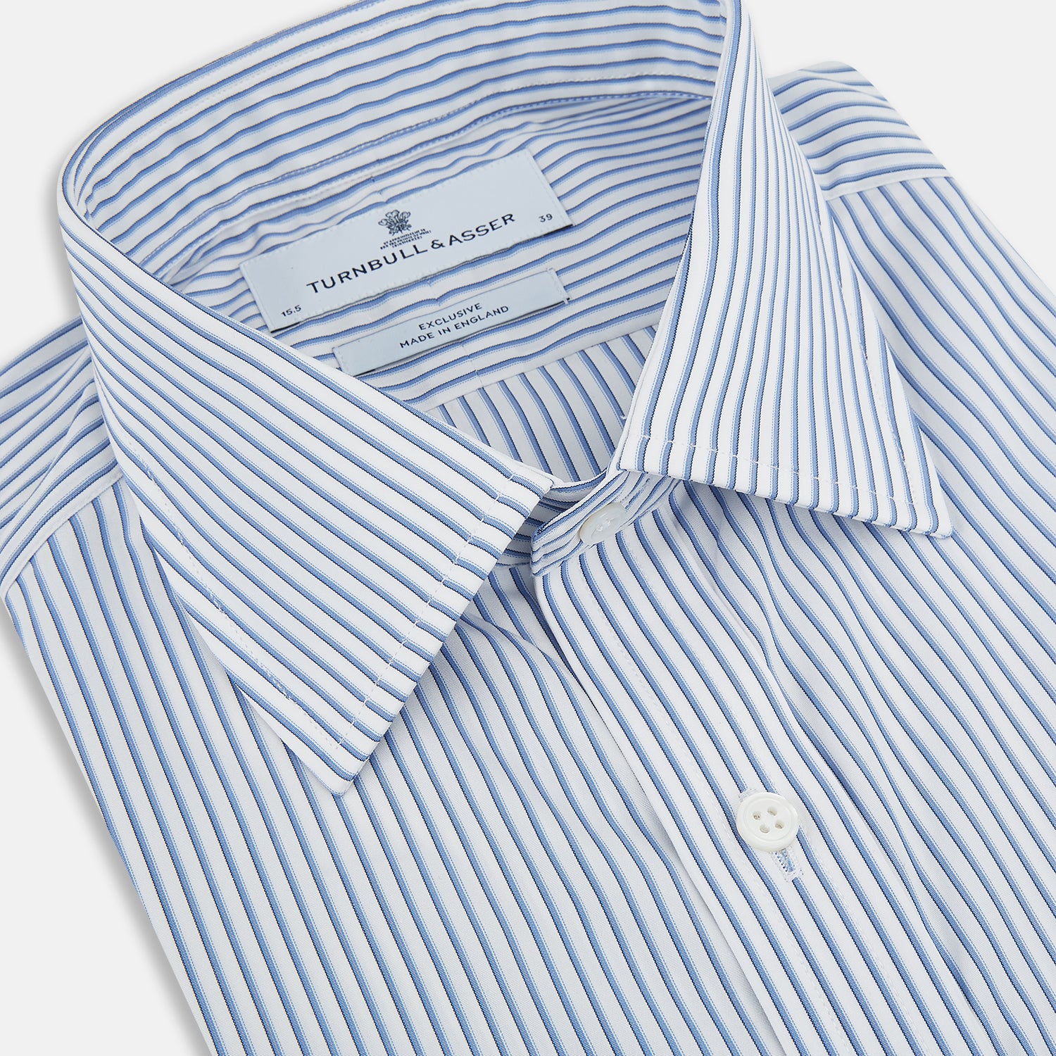 View 2 of product The Turnbull & Asser Blue Shadow Stripe Mayfair Shirt is a long-sleeve button-up with a T&A collar and thin blue vertical stripes on white, shown on a plain white background.