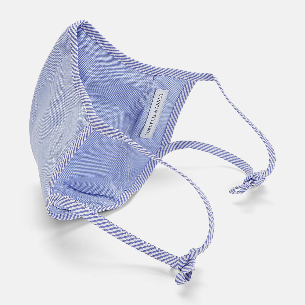 The Turnbull & Asser Blue Fine Check Zephyr Cotton Commuter Mask features a light blue and white check pattern, adjustable side ties, and comes with 3 Viroformula™ filters. Shown on a plain white background.