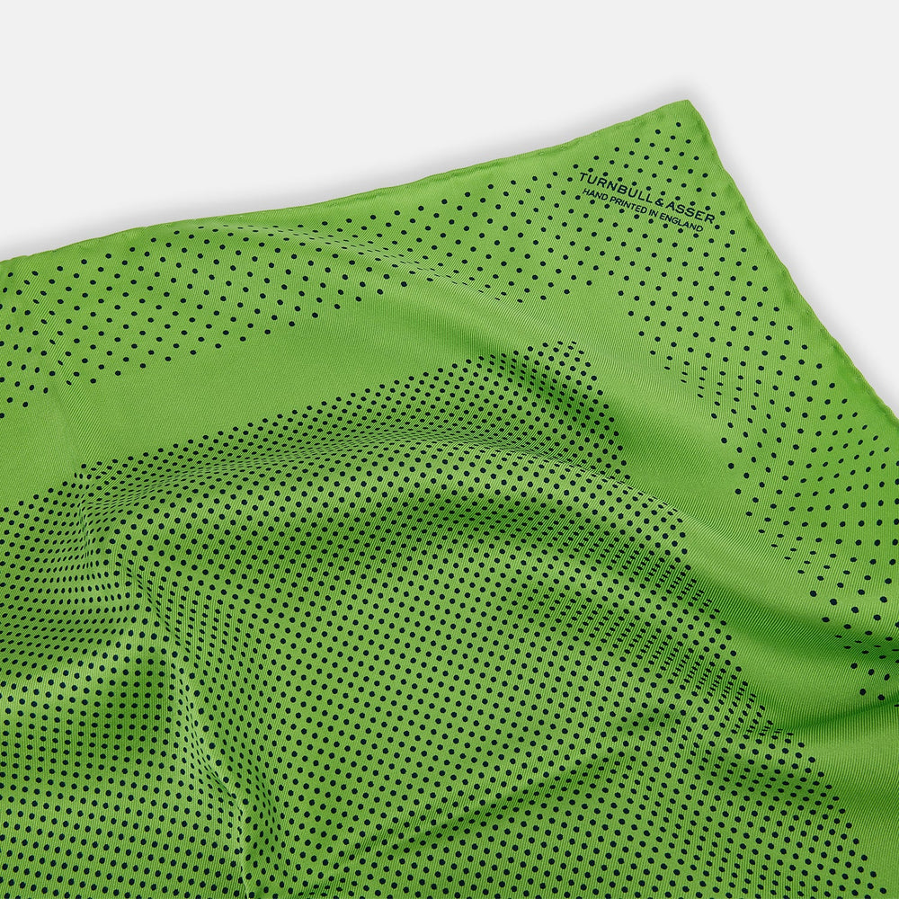 The Turnbull & Asser Kelly Green Dot Silk Pocket Square features small black polka dots and is shown neatly folded to showcase both its front and inner sides.