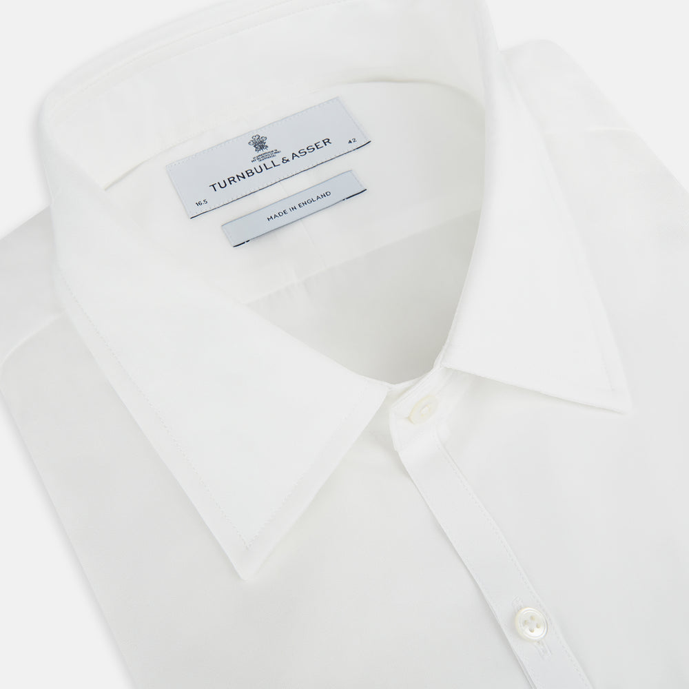 The PLAIN WHITE WESTMINSTER SHIRT WITH TURNBULL COLLAR AND 3-BUTTON CUFFS by Turnbull & Asser features refined British craftsmanship, long sleeves, a straight hem, and a crisp white design displayed on a plain background.