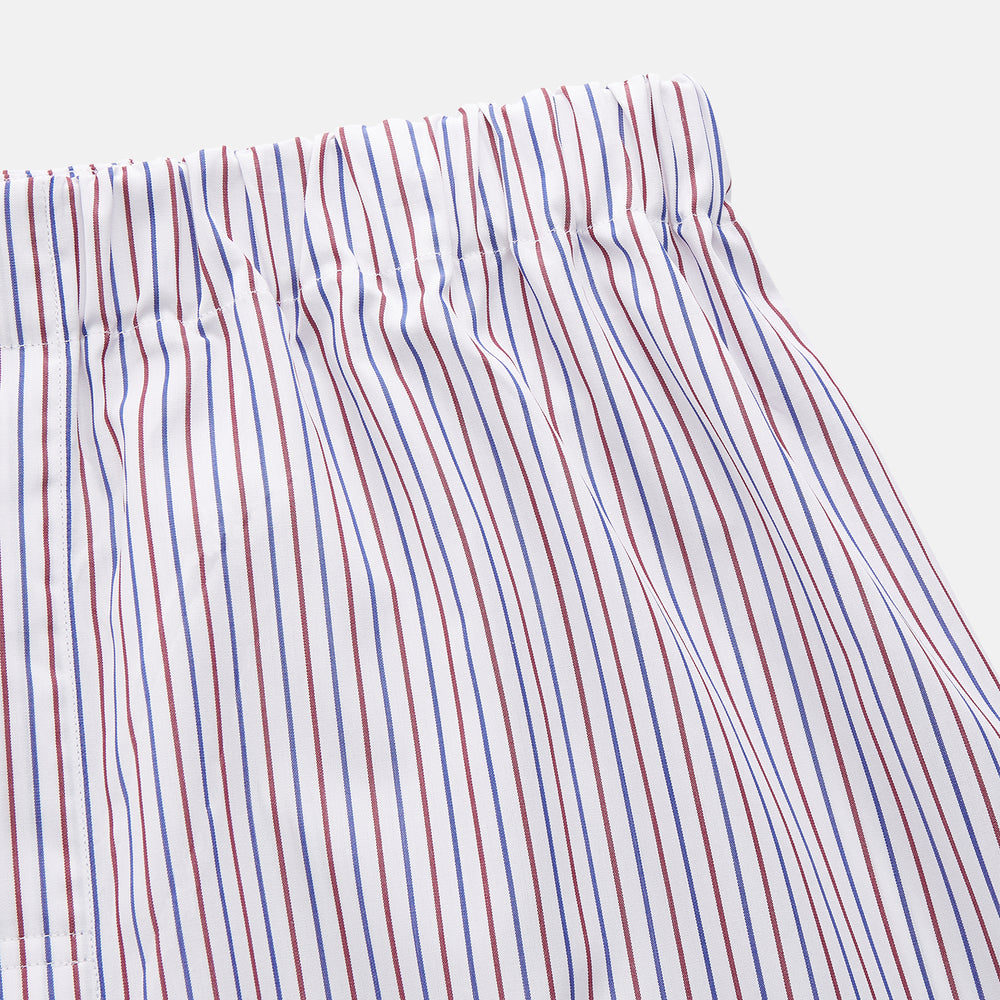 The Turnbull & Asser Red and Blue Stripe Cotton Hastings Pyjama Trousers feature a loose fit with an elastic waistband for comfort, showcasing bold red and blue stripes on soft cotton, displayed against a plain white background.