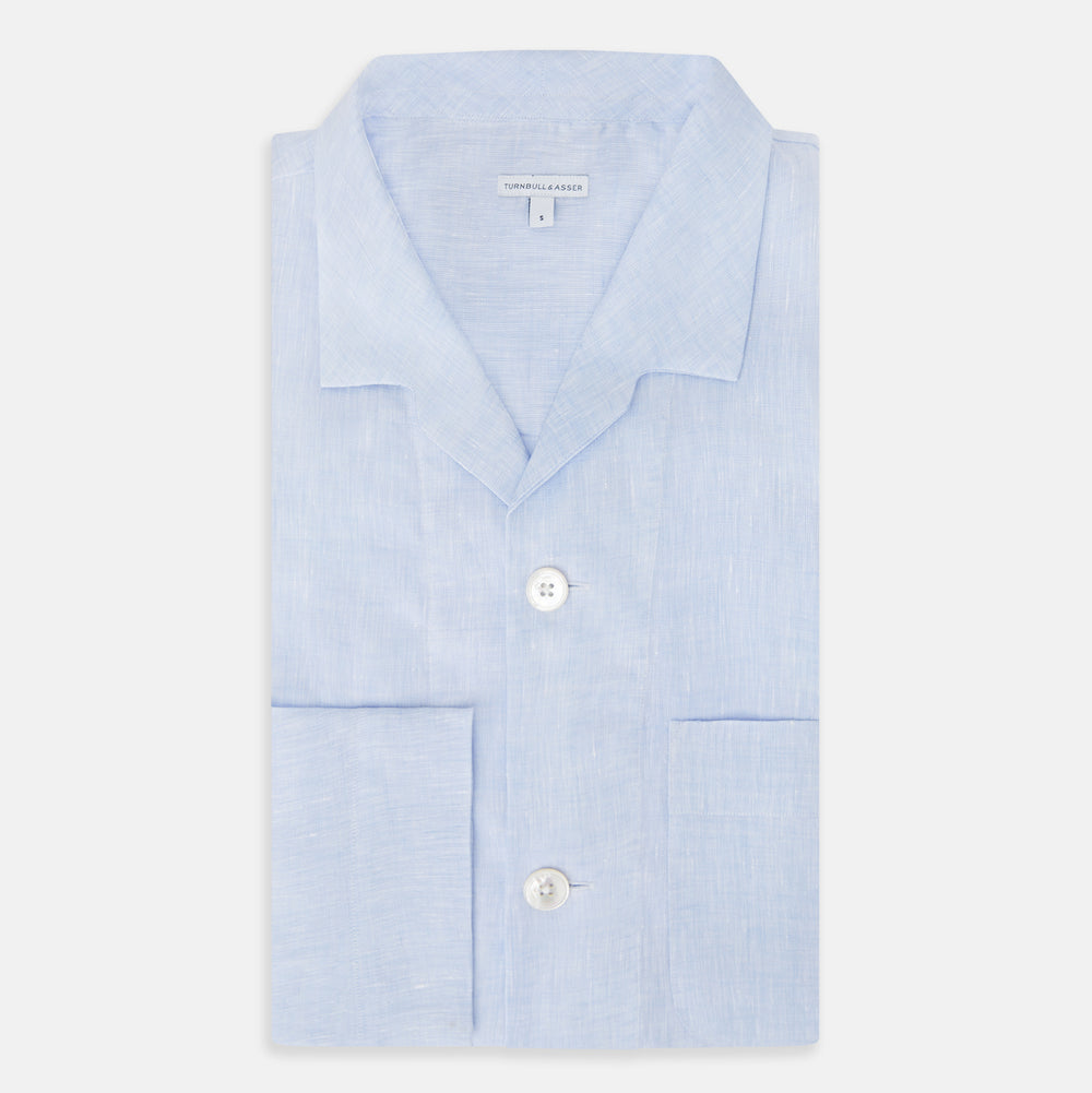 The Turnbull & Asser Pale Blue Linen Pyjama Shirt features long sleeves, a collar, front buttons, and a chest pocket—perfect as elegant loungewear or nightwear.