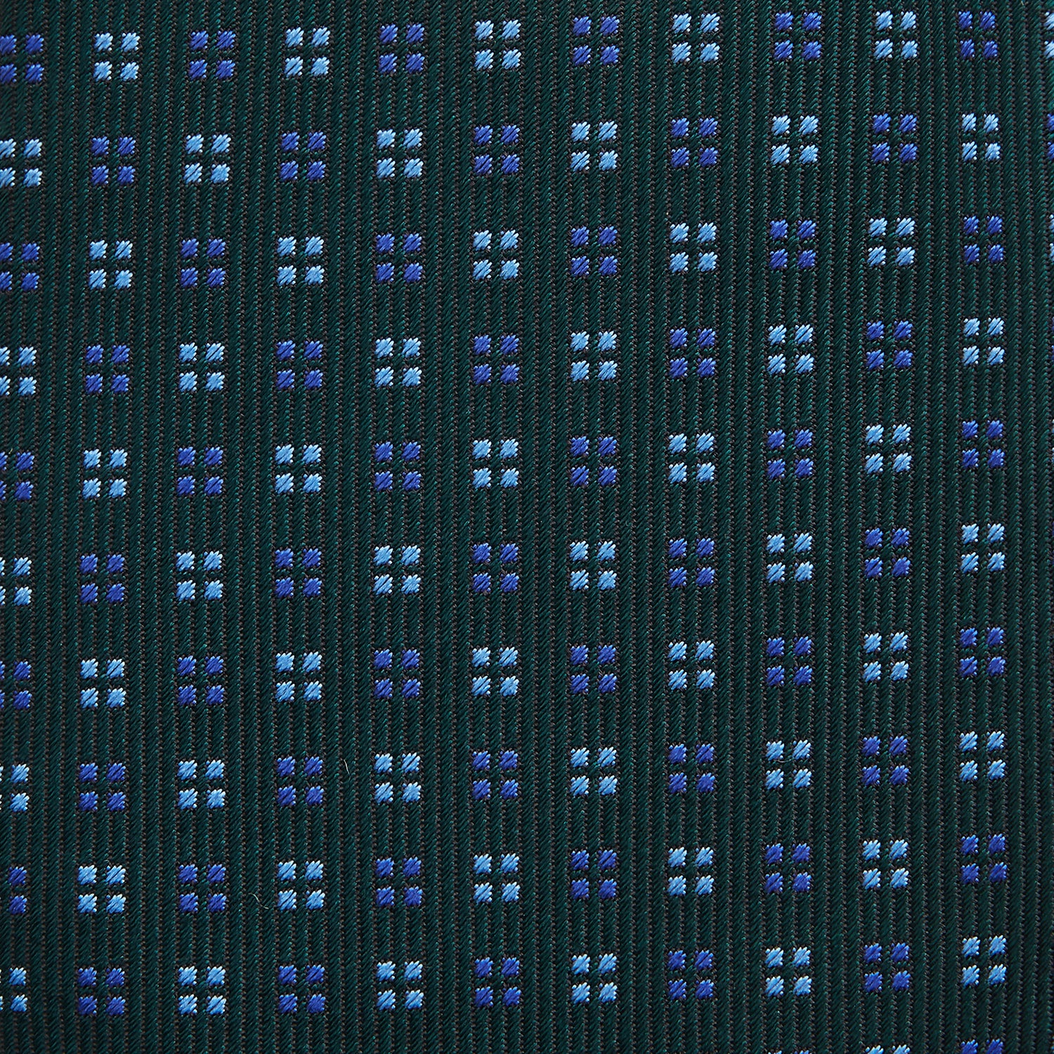 View 3 of product The MINI SQUARE SPOT FOREST GREEN BLUE TIE by Turnbull & Asser is a classic men's accessory, featuring a rolled-up green silk design with small blue geometric patterns—perfect for the modern gentleman.