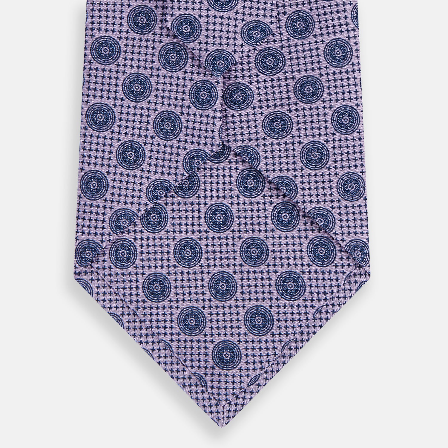 View 3 of product The Turnbull & Asser Lilac Medallion Silk Tie features a repeating navy medallion motif on textured lilac silk, adding refined style to any ensemble.