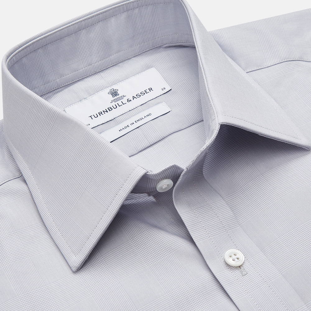 The Turnbull & Asser Faded Blue Block Check Cotton Regular Fit Mayfair Shirt, featuring long sleeves, a classic collar, and white buttons, is neatly laid flat on a white background.