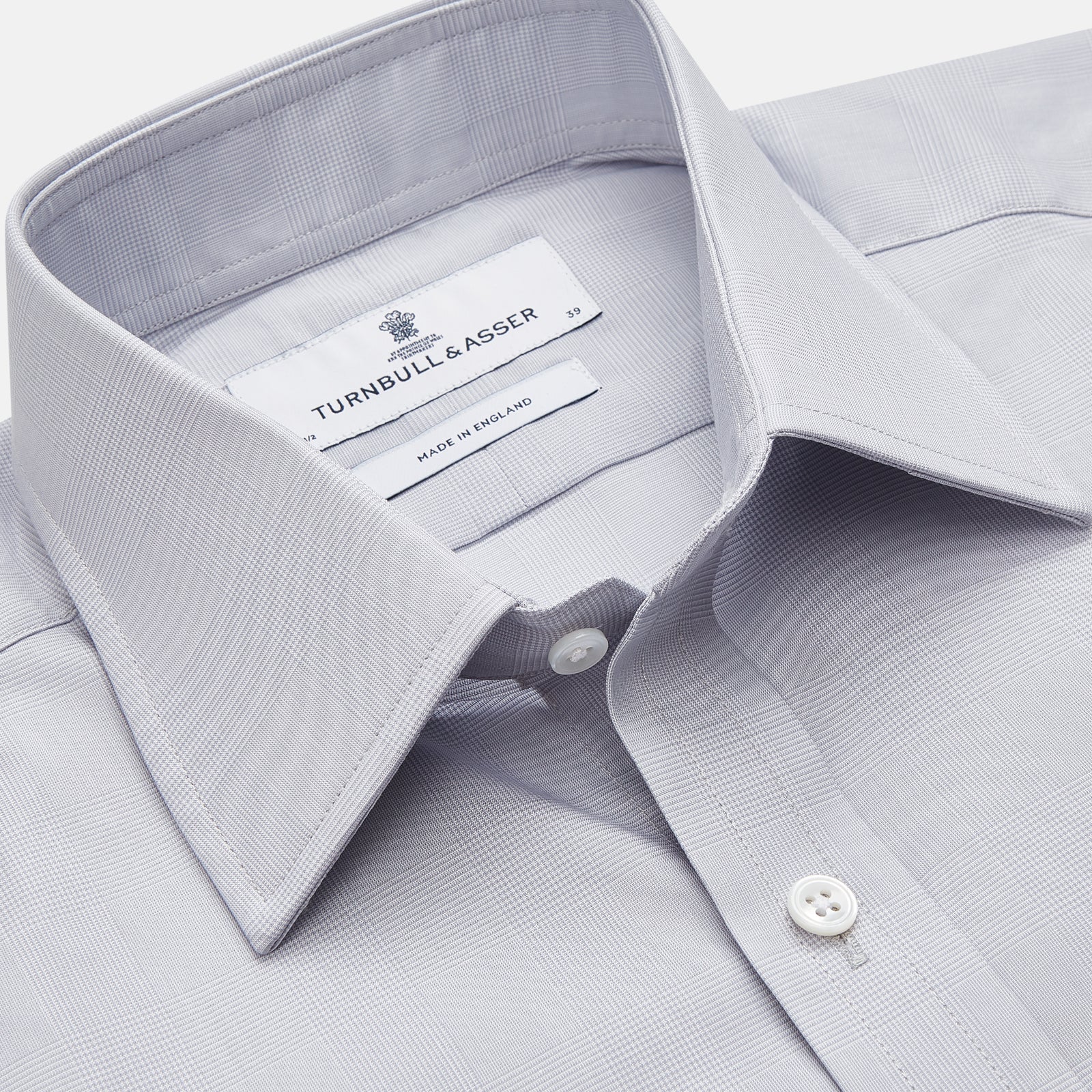 View 2 of product The Turnbull & Asser Faded Blue Block Check Cotton Regular Fit Mayfair Shirt, featuring long sleeves, a classic collar, and white buttons, is neatly laid flat on a white background.