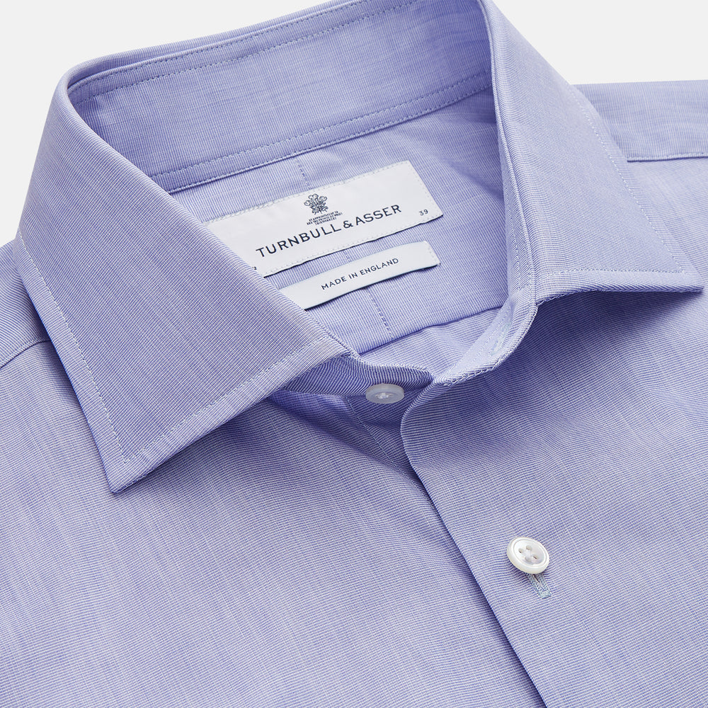 The Turnbull & Asser Tailored Fit Blue End-on-End Cotton Shirt features a Kent collar, double cuffs, and sleek white buttons—an ideal match for a navy suit to complete a sophisticated look. Displayed on a white background.