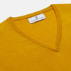View 2 of product The Gold Paden Cashmere V-Neck Jumper by Turnbull & Asser features a bright yellow hue, long sleeves, ribbed cuffs and hem, and a classic design. It is shown laid flat on a white background.