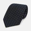 View 1 of product The Turnbull & Asser Green and Navy Micro Dot Silk Tie features small green dots on a navy silk background, displayed rolled up on white.