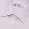View 5 of product The Turnbull & Asser Pink Herringbone Superfine Cotton Shirt features a T&A collar, double cuffs, and clean-cut design, displayed neatly folded against a white background.
