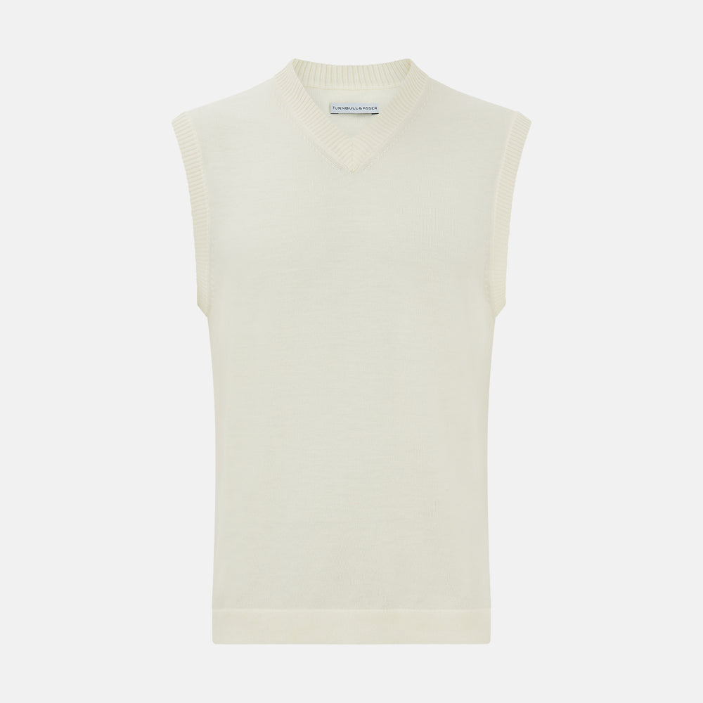 The Ecru Fine Merino V-Neck Vest by Turnbull & Asser is a sleeveless gentleman’s sweater with ribbed edges in cream knit, shown against a plain white background.
