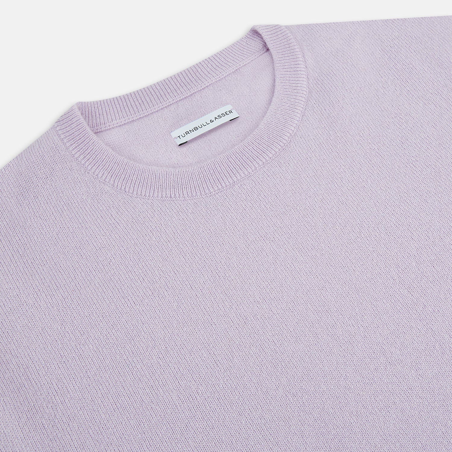 View 2 of product The Turnbull & Asser Lilac Cashmere Round Neck Jumper for men features long sleeves with ribbed cuffs and hem, offering a stylish, refined look. Shown against a white background.