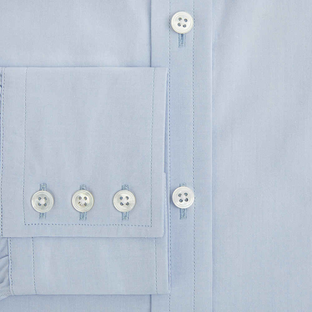 The Pale Blue Mayfair Shirt by Turnbull & Asser is a long-sleeve, button-up dress shirt with a pointed collar and buttoned cuffs, crafted from sanforised cotton and shown laid flat on a white background.
