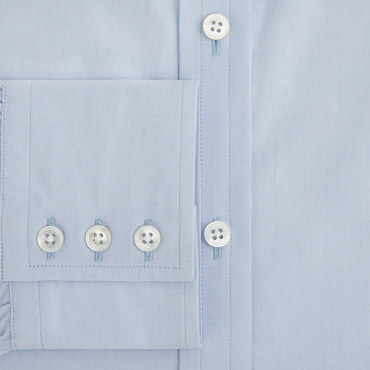 View 4 of product The Pale Blue Mayfair Shirt by Turnbull & Asser is a long-sleeve, button-up dress shirt with a pointed collar and buttoned cuffs, crafted from sanforised cotton and shown laid flat on a white background.