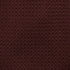 View 3 of product The Turnbull & Asser Dark Red Knitted Tie, featuring a textured finish, is shown rolled up against a white background—a stylish and versatile accessory ideal for the modern gentleman.