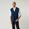 View 1 of product A man with a shaved head wears a Turnbull & Asser Navy Sleeveless Cashmere Cardigan over a white dress shirt with rolled-up sleeves and dark trousers, standing against a plain light gray background.