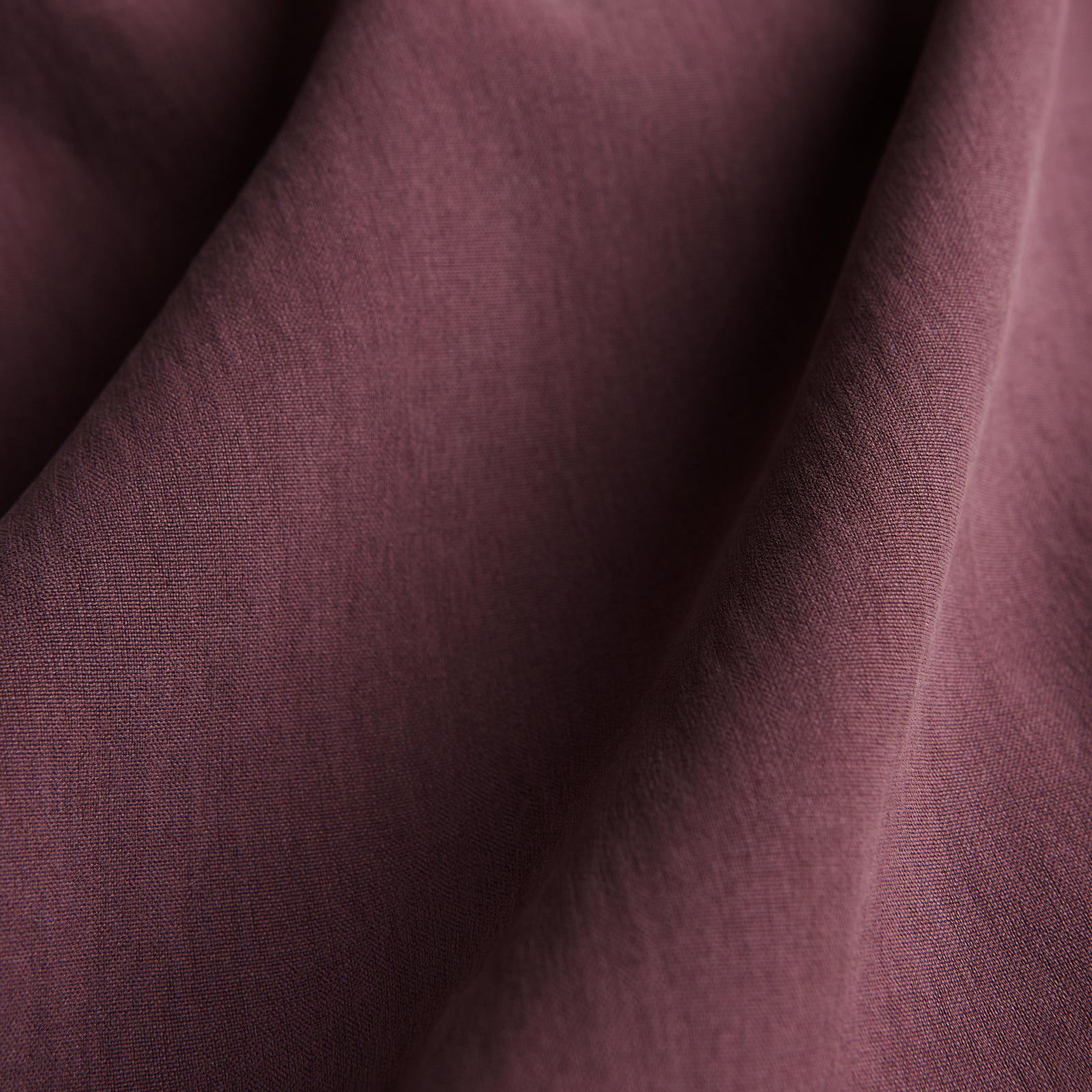 View 4 of product The Turnbull & Asser Plain Plum Silk Modern Pyjama Set, made in England, features white piping, a button-up long-sleeve top with three pockets, and matching pants. The pyjamas are shown against a white background.