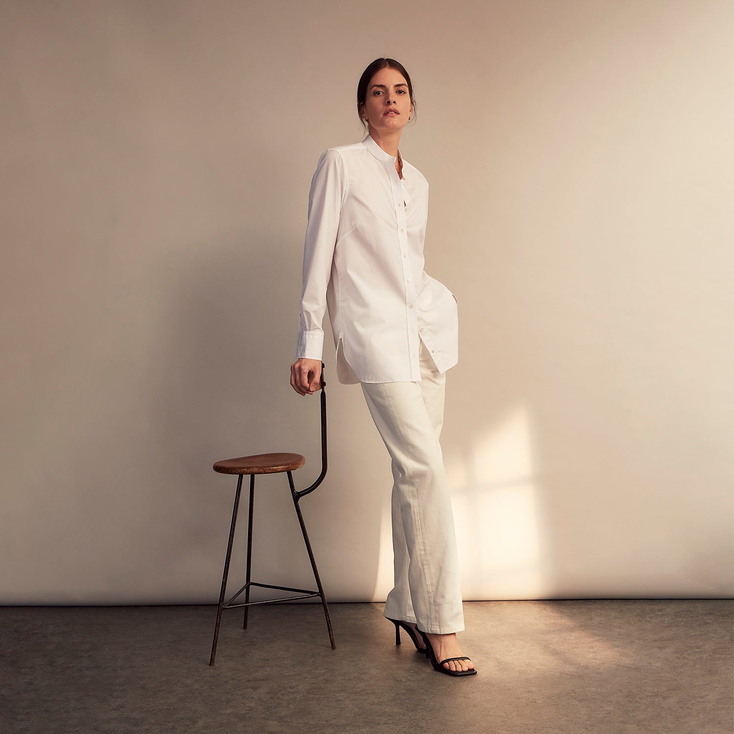 View 12 of product The White Cotton Lauren Shirt by Turnbull & Asser, featuring a stand collar, button-down front, and elongated body, is laid flat on a plain white background.