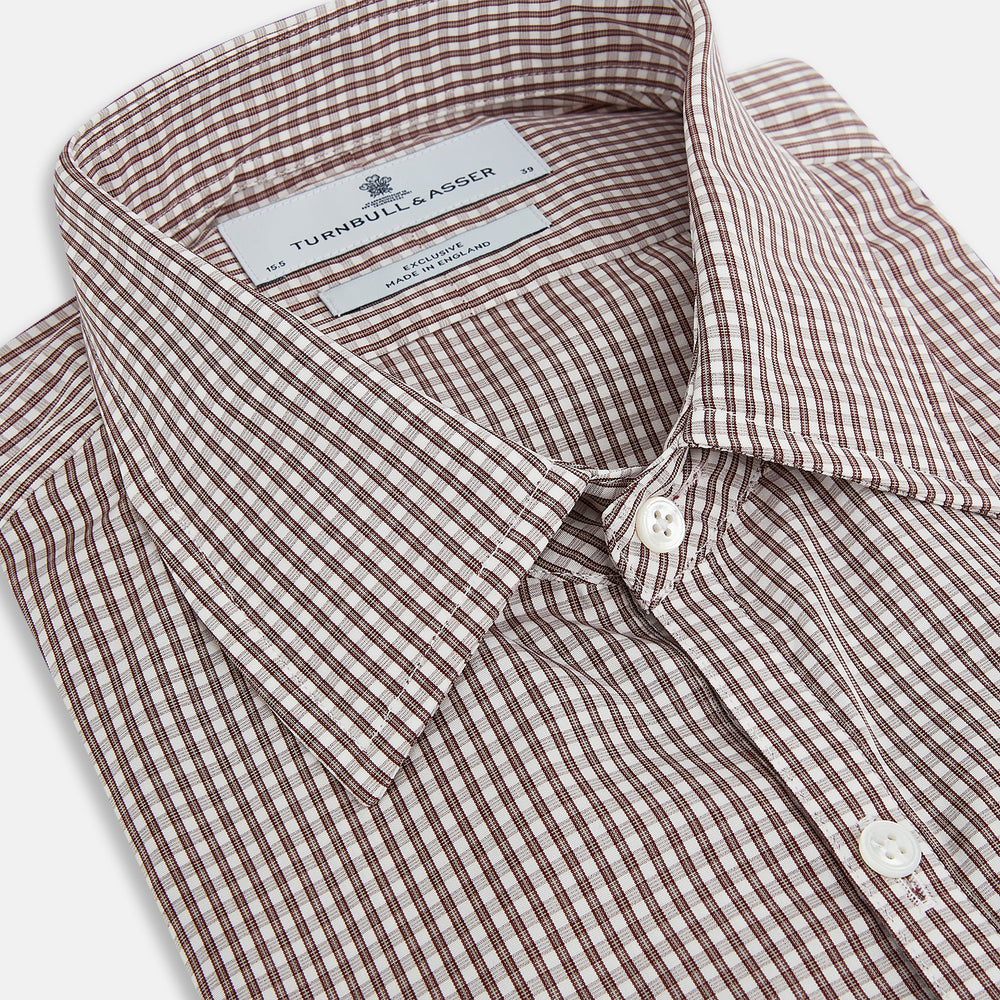 The Turnbull & Asser Burgundy Micro Check Westminster Shirt is a long-sleeved button-up with a classic collar and tailored fit, featuring a subtle micro check pattern, shown against a white background.